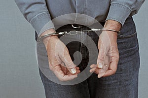 Man wearing jeans and shirt handcuffed