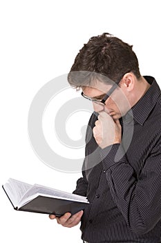 A man wearing jeans and shirt reading a fantasctically interÃÆsting book