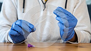 A man wearing latex gloves holding a cotton swab for nose to check COVID19 virus