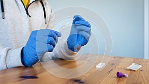 A man wearing latex gloves holding a cotton swab for nose to check COVID19 virus