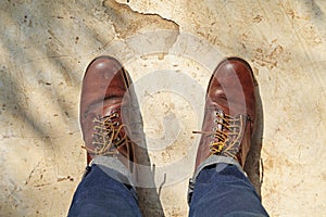 man wearing leather boots standing on cement floor. close up safety shoes