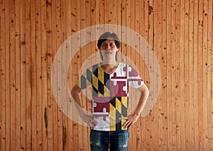Man wearing Maryland flag color shirt and standing with akimbo on the wooden wall background