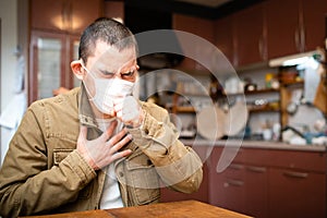 Man wearing a mask and coughing painfully