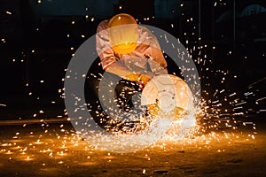 Man wearing mask with his hands grinding in heavy industry