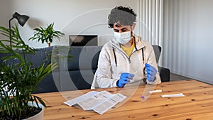 A man wearing mask at home reading instructions on supply Covid19 rapid antigen