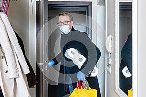 Man wearing medical mask coming home from shopping and hoarding