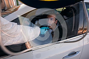 Man wearing an NBC personal protective equipment ppe suit, gloves, mask, and face shield, testing covid-19 coronavirus on