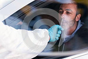 Man wearing an NBC personal protective equipment ppe suit, gloves, mask, and face shield, testing covid-19 coronavirus on