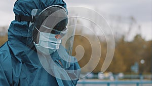 Man wearing NBC personal protective equipment ppe suit, mask, goggles and face shield. Preventing coronavirus spread