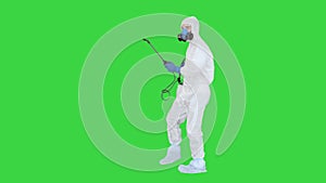 Man wearing an NBC personal protective equipment spray disinfectant and dancing on a Green Screen, Chroma Key.