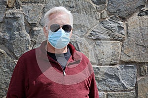 Man wearing a paper mask on his face. A man wears a Medical Face Mask to help avoid contracting Coronavirus aka Covid-19. Covid-19