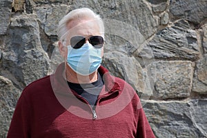 Man wearing a paper mask on his face. A man wears a Medical Face Mask to help avoid contracting Coronavirus aka Covid-19. Covid-19