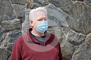 Man wearing a paper mask on his face. A man wears a Medical Face Mask to help avoid contracting Coronavirus aka Covid-19. Covid-19