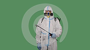 Man wearing personal protective suit, safety glasses, a respirator and gloves disinfects and decontaminats infected area