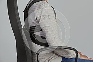 Man wearing a posture corrector while sitting