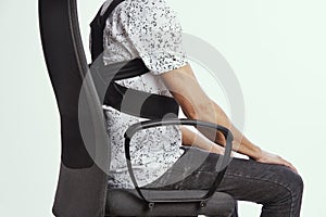 Man wearing a posture corrector while sitting
