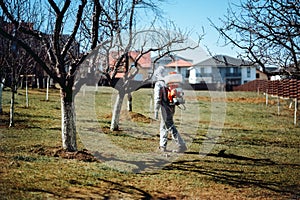 A man wearing protective clothing and spraying pesticides and other organic chemicals