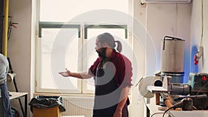 Man wearing protective equipment while using angle grinder to sander plank