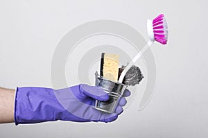 Man wearing protective glves for cleaning and holding little bucket full of supplies for washing, cleaning house