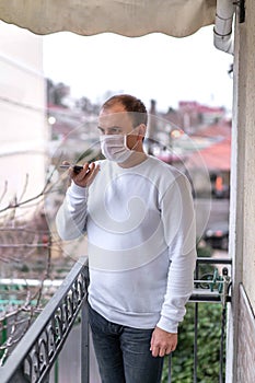 A man wearing a protective mask against the spread of coronavirus disease and talking on a cell phone.