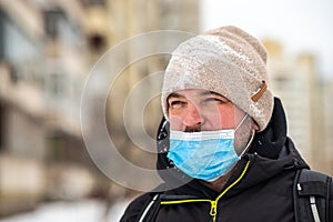 Man wearing a protective mask close-up. The mask covers the mouth. Nose without mask protection.