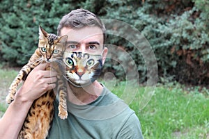 Man wearing protective mask with print of his catÂ´s face