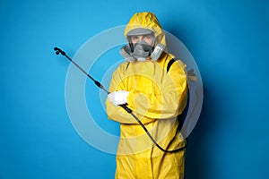 Man wearing protective suit with insecticide sprayer on background. Pest control