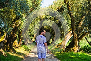 A man wearing purple out of focus walking alone in the forest, sun flares landscape.enjoy the clean environment weather