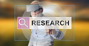 Man wearing a reality virtual headset touching a research concept on a touch screen