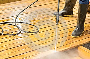 Man wearing rubber boots using high water pressure