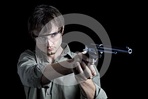 Man wearing safety glasses aiming pistol