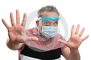 Man wearing screen and mask making stay away gesture with hands