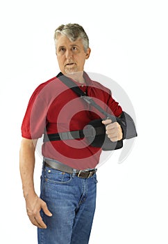 Man wearing a shoulder surgery sling with abduction pillow during recovery and healing