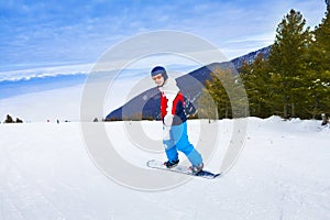 Man wearing ski mask standing on snowboard