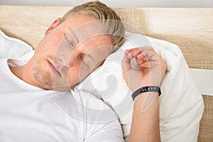 Man wearing smart wristband while sleeping