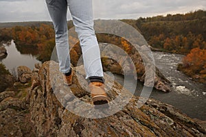 Man wearing stylish hiking boots on steep cliff, closeup