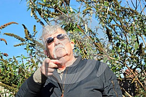 Man wearing sun glasses pointing.