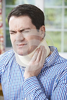 Man Wearing Surgical Collar In Pain