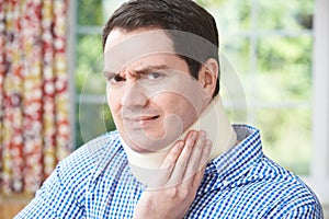 Man Wearing Surgical Collar In Pain