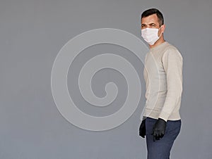 Man wearing surgical face mask isolated on grey