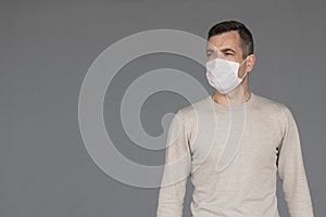 Man wearing surgical face mask isolated on grey