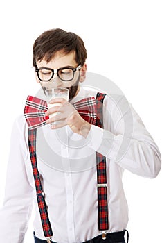 Man wearing suspenders drinking milk.