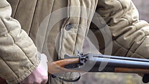 Man wearing Telogreika Loads a gun inserts ammo to a shotgun weapon with a sound