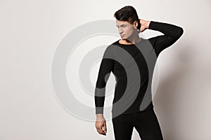 Man wearing thermal underwear on grey background. Space for text