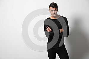 Man wearing thermal underwear on light grey. Space for text