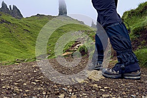 Man wearing trekking boots and gaiters walking to the Old man of Storr