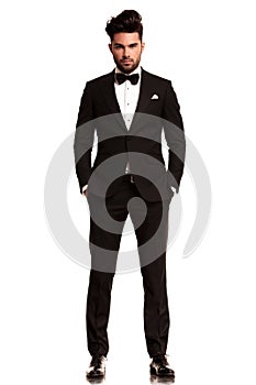 Man wearing tuxedo standing with hands in pockets