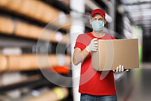 Man wearing uniform and medical mask with box in store. Wholesale market