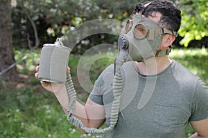 Man wearing vintage gas mask in natural setting