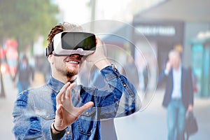 Man wearing virtual reality goggles. Crowded street of London.